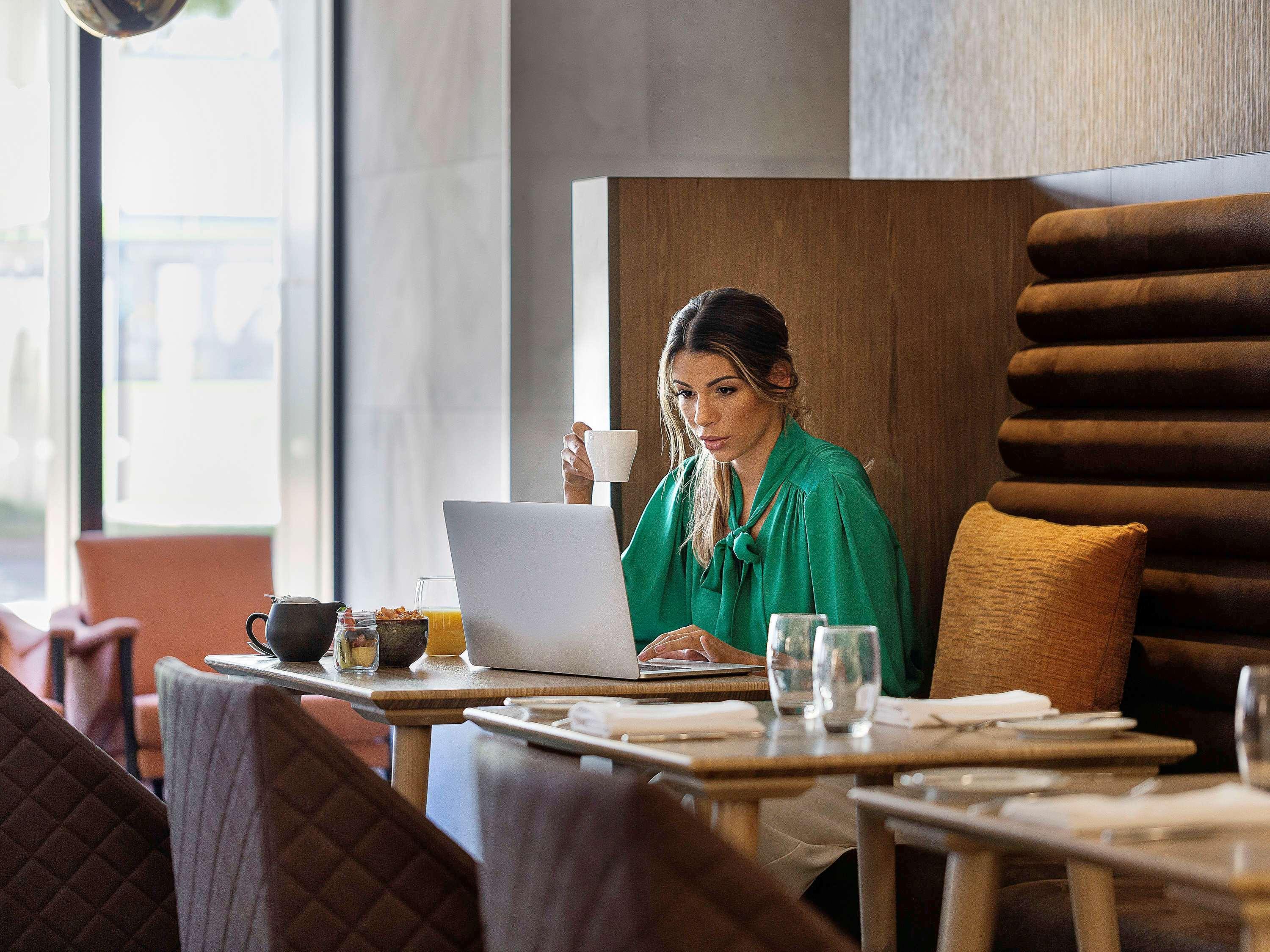 Hotel Pullman Rotorua Exteriér fotografie A woman working on a laptop